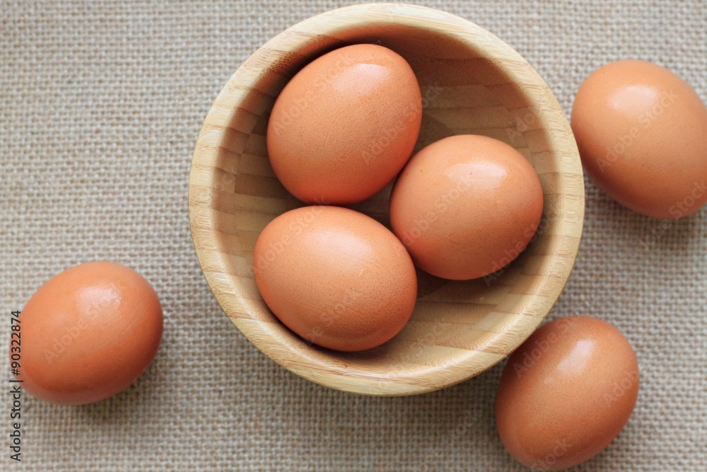 brown chicken eggs wooden bowl canvas background