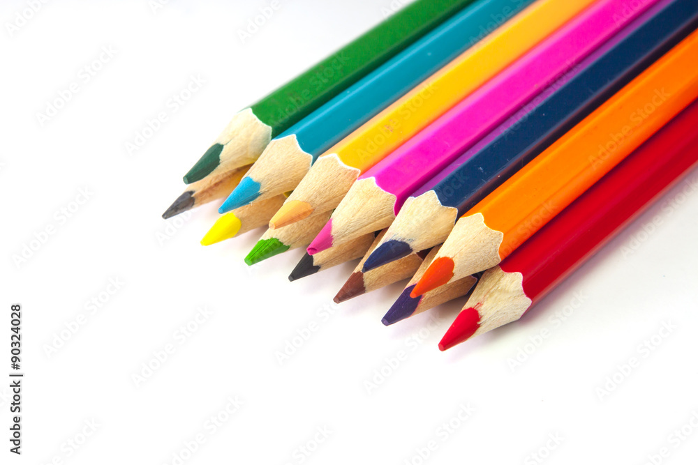 Line of colored pencils isolated on white background close up