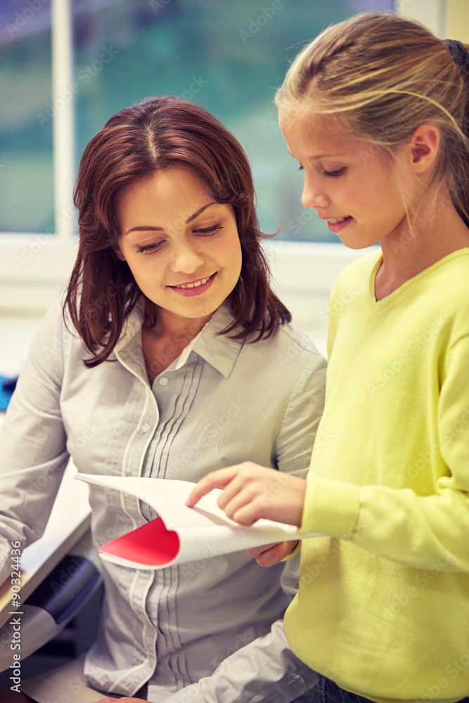 school girl with notebook and teacher in classroom