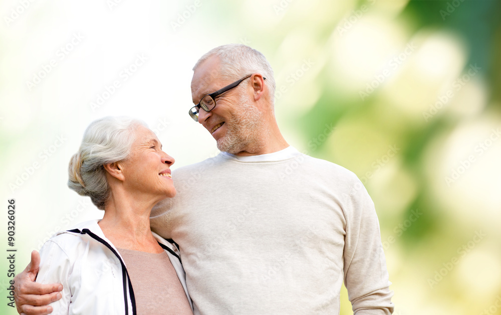 happy senior couple over green natural background
