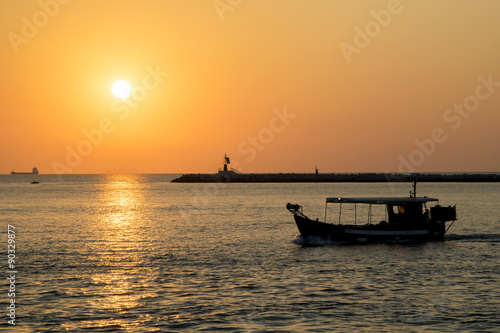 Passaggio di una barca nel porto sulla laguna durante l'alba