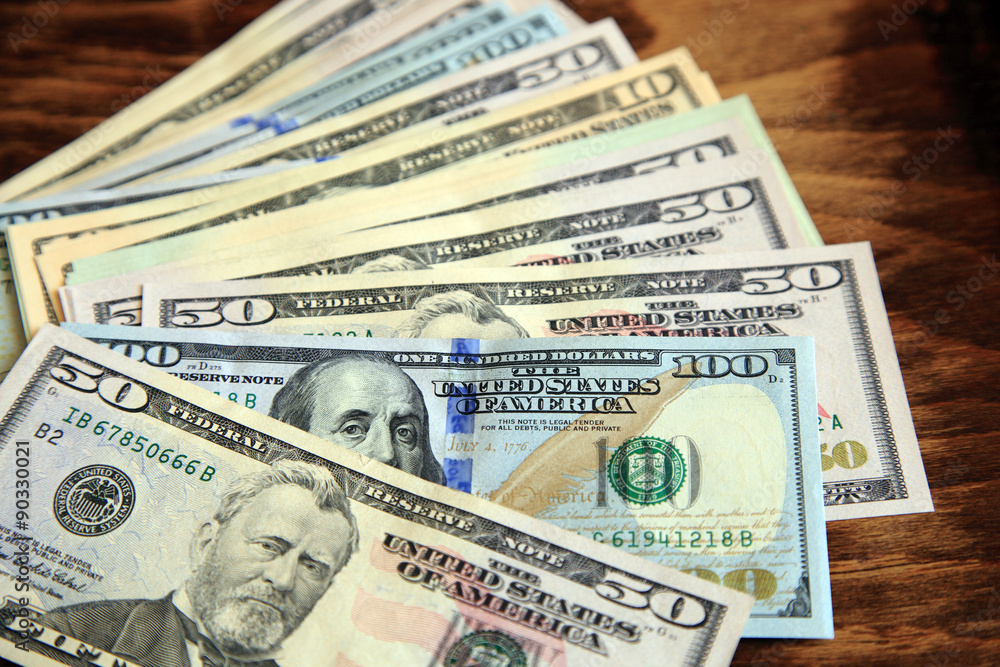 Dollar bills on the dark wood surface Dollar bills on the dark wood surface