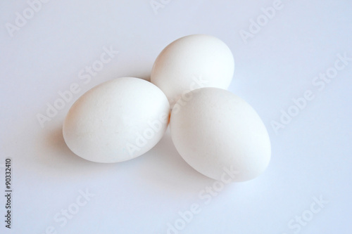 Three white hen eggs on a white background