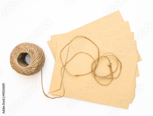 old brown envelope isolated with skein of twine on a white background