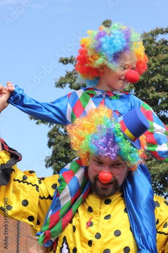 A father and son dressed as clowns on a summers day