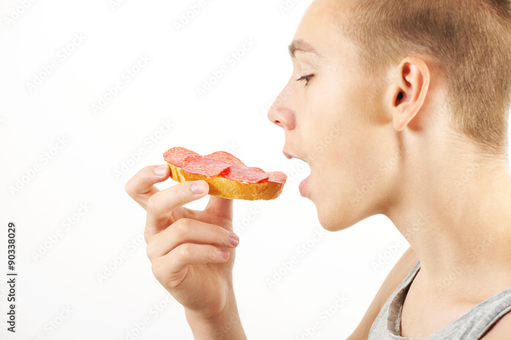Young man eats small snack, opened mouth, side view Young man eats small snack, opened mouth, side view