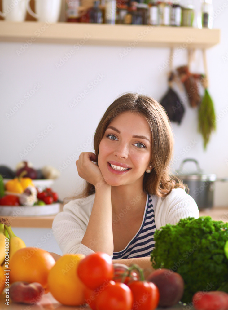 Young woman sitting near desk in the kitchen Young woman sitting near desk in the kitchen