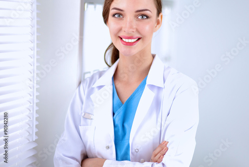 Woman doctor is standing near window 