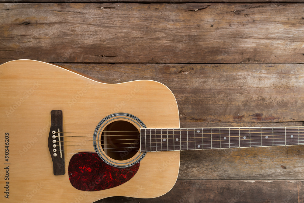 Fototapeta premium Top view of guitar on dark wood floor texture in darken tone