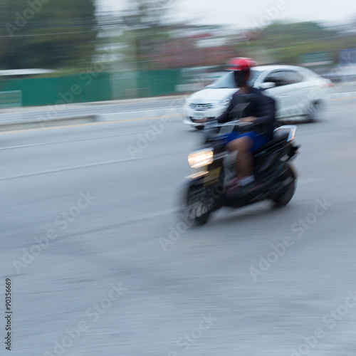 car and motorcycle driving on road with traffic jam in the city, abstract blurred