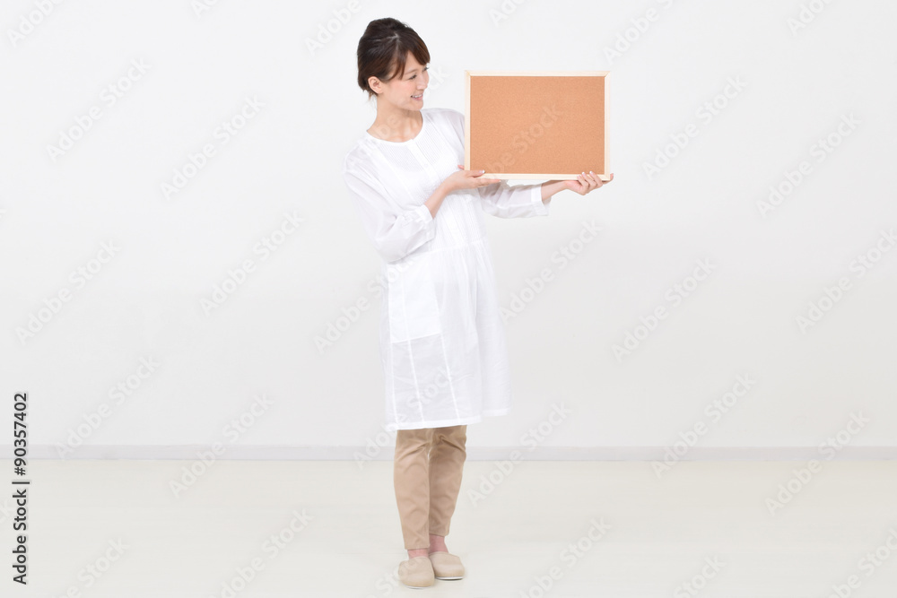 コルクボードを笑顔で持つ女性