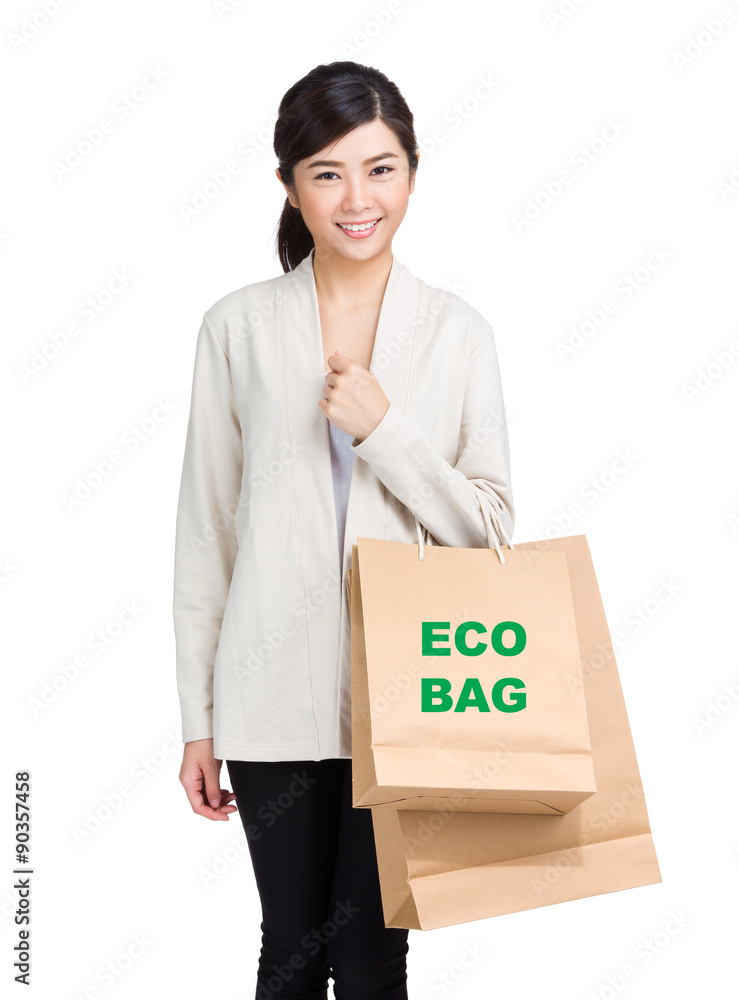 Young woman holding shopping bag and showing eco bag Young woman holding shopping bag and showing eco bag