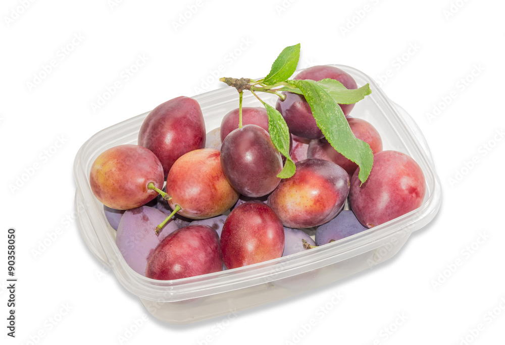 Plums in plastic tray on a light background Plums in plastic tray on a light background