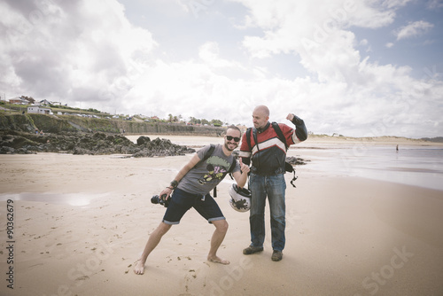 Strange friends on the beach; photgrapher smiling and biker gett