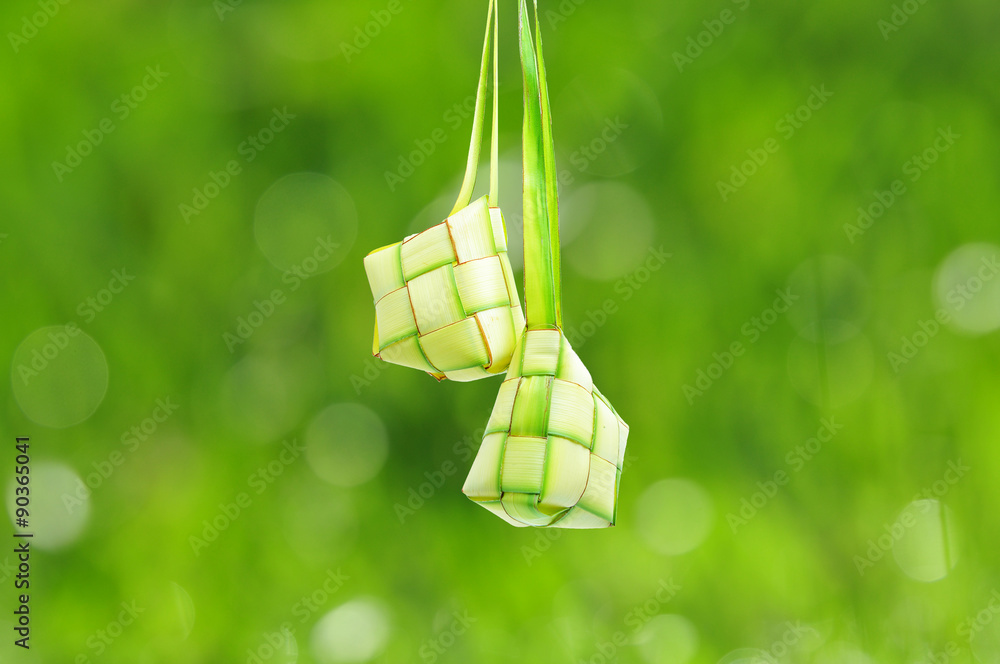 Ketupat or rice dumpling is a local delicacy during the festive season. Ketupat, a natural rice casing made from young coconut leaves for cooking rice on a bokeh or blur background.
