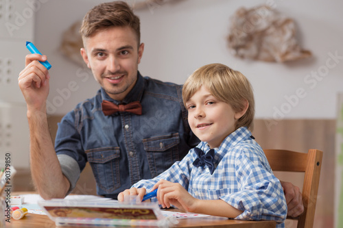 Male babysitter with boy drawing