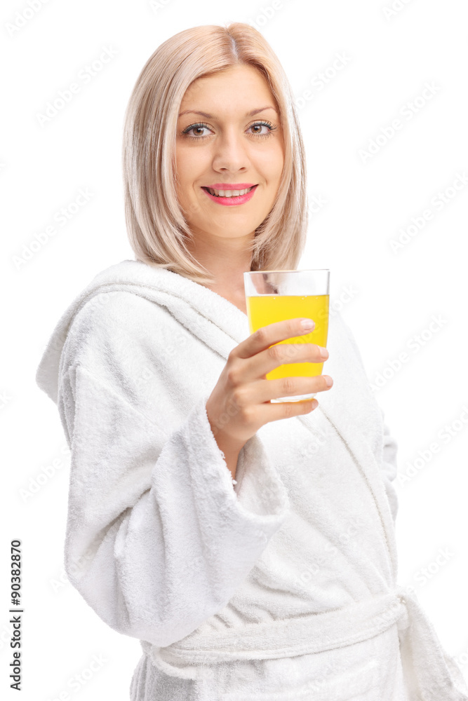 Young girl in a bathrobe holding an orange juice Young girl in a bathrobe holding an orange juice