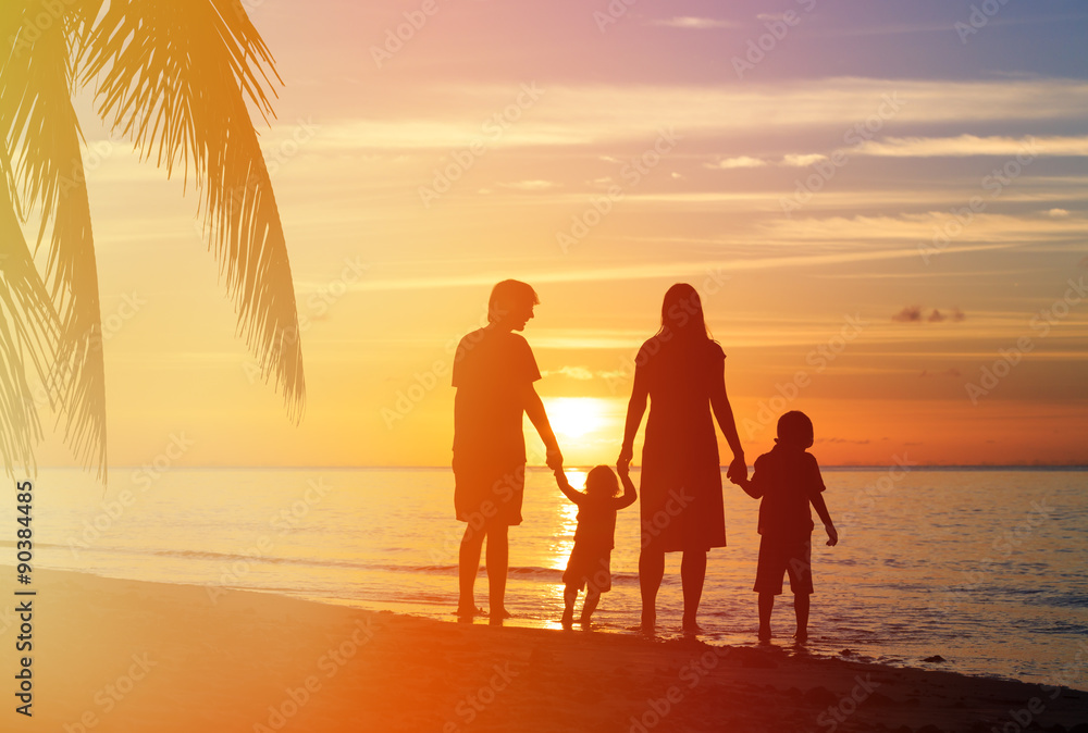 Fototapeta premium happy family with two kids having fun on sunset beach