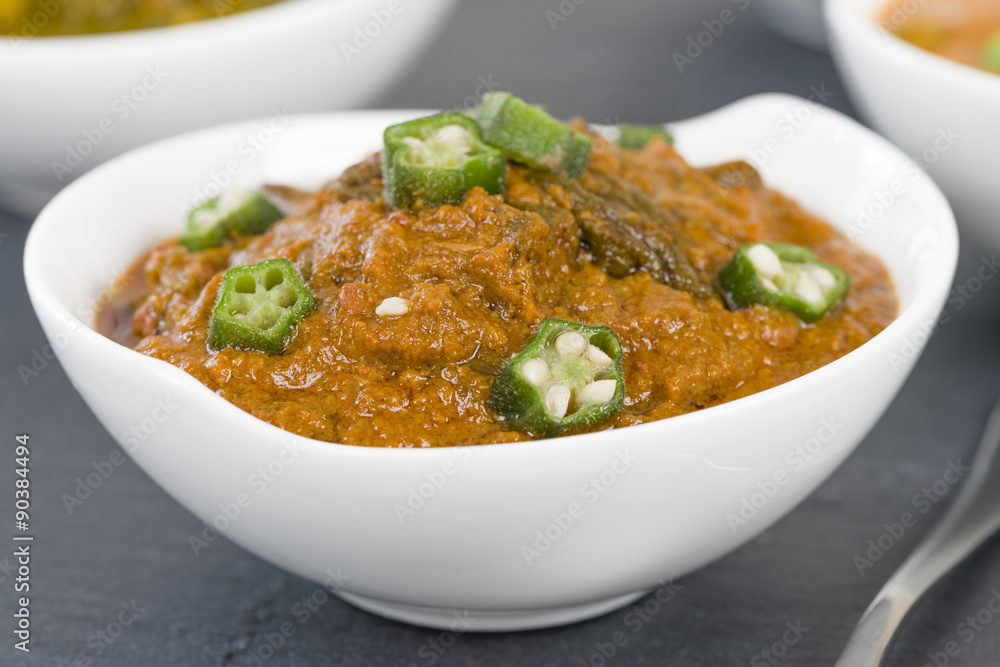 Bhindi Masala - Spiced okra in thick gravy. Chapattis and other vegetarian curries on background.
Bhindi Masala - Spiced okra in thick gravy. Chapattis and other vegetarian curries on background.