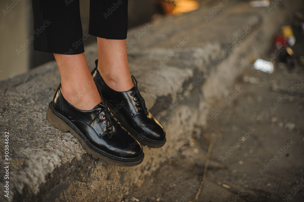 Closeup of young woman legs wearing black shoes