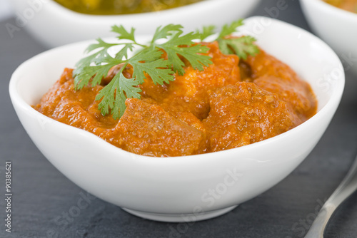 Paneer Makhani - Indian cheese cooked in a creamy sauce. Chapattis and other vegetarian curries on background.
 photo