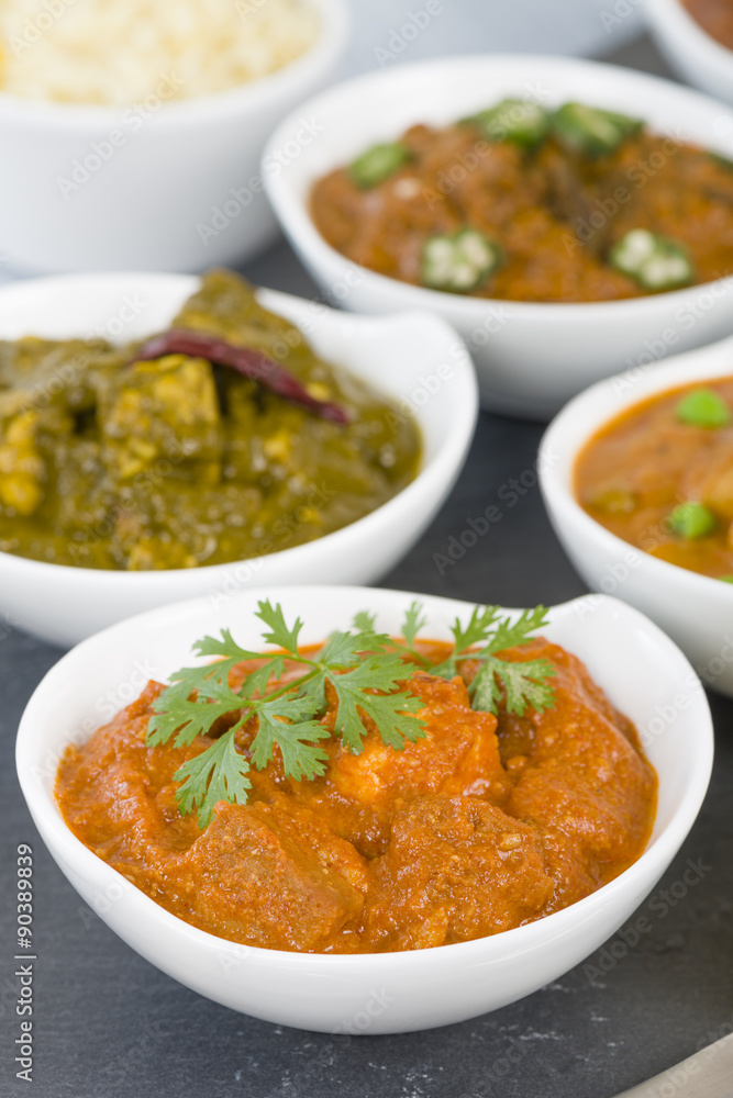 Paneer Makhani - Indian cheese cooked in a creamy sauce. Chapattis and other vegetarian curries on background.
