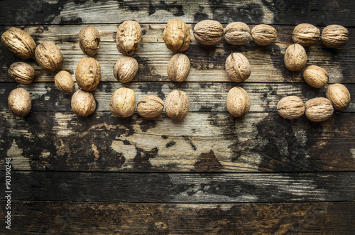 walnuts, laid out in the word "nuts" on wooden rustic background, top view