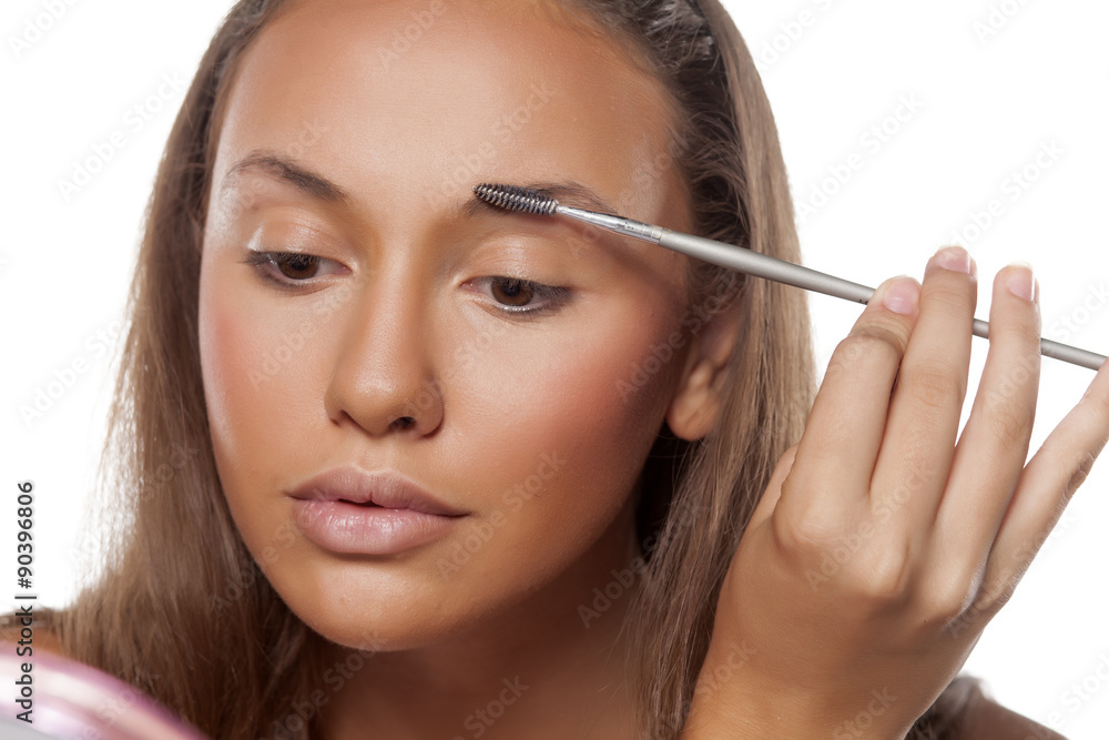 girl comb her eyebrows with a brow brush girl comb her eyebrows with a brow brush