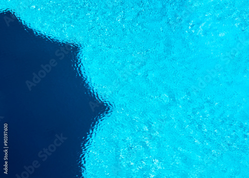 Giant parasol shadow in pool water