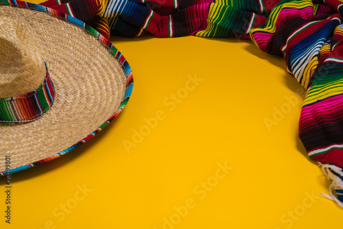 Mexican Sobrero and Serape blanket on yellow background with cop