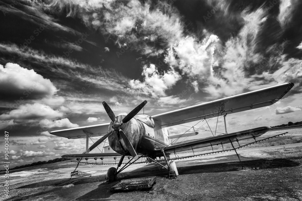Fototapeta premium Stary samolot na polu w czerni i bieli