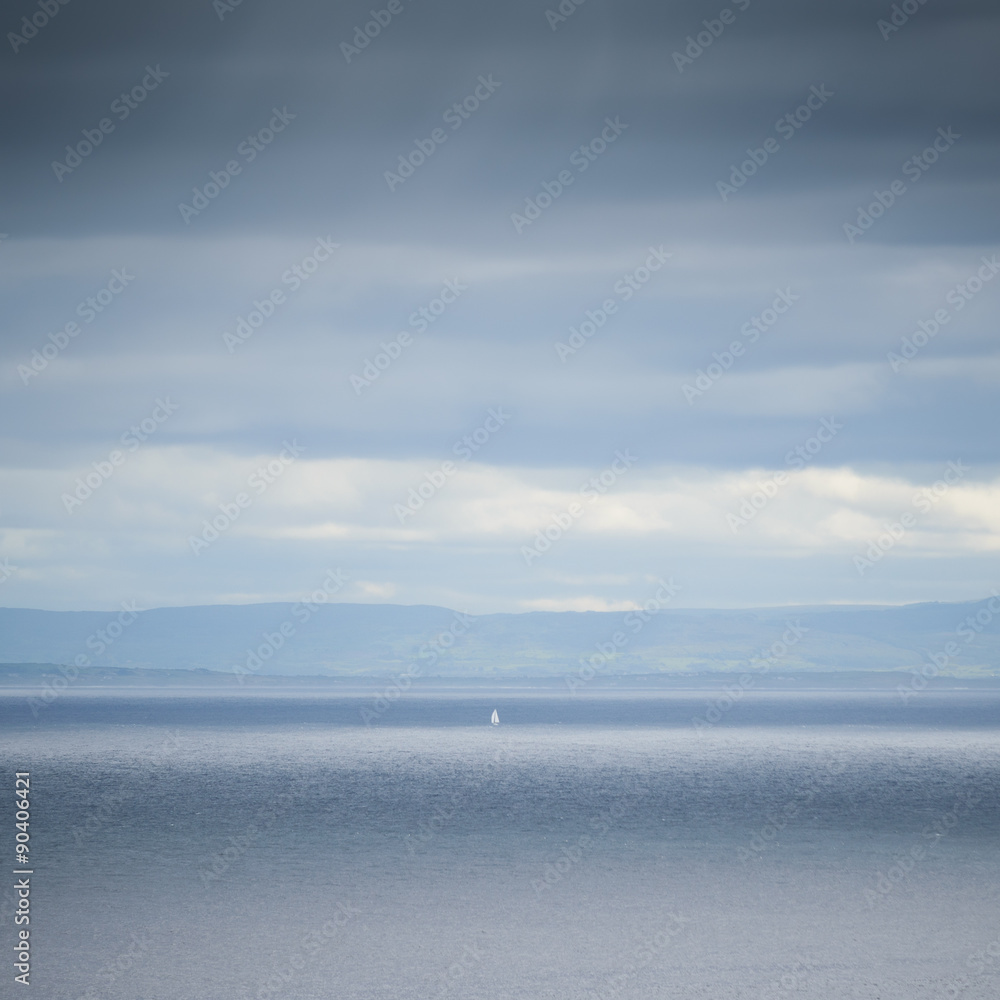 Lone White Sail in the sea mist blue, Donegal, Ireland