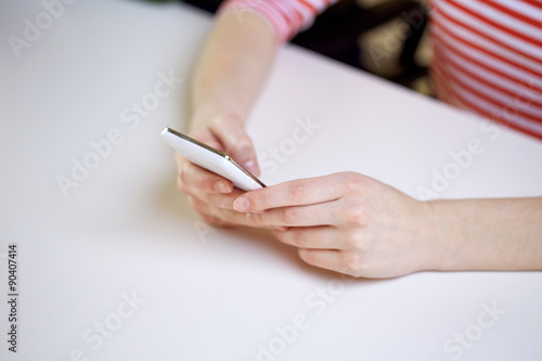 close up of female hands with smartphone at home