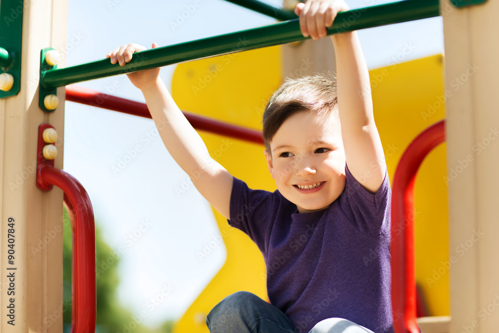 Fototapeta premium happy little boy climbing on children playground
