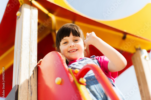 happy little girl climbing on children playground