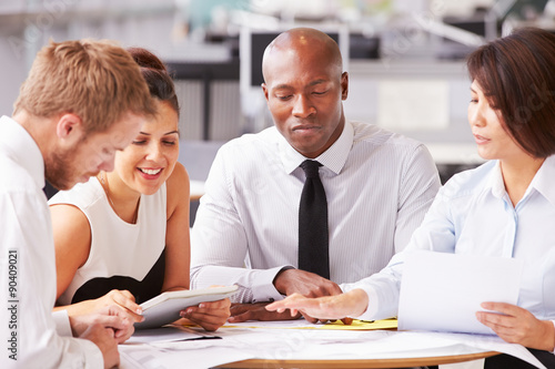 Four office colleagues in a casual team meeting