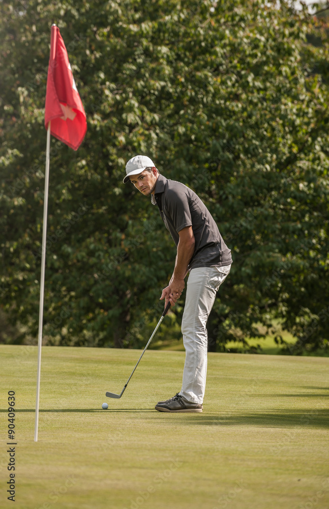Fototapeta premium Portrait of a middle aged man playing golf on a nice course.