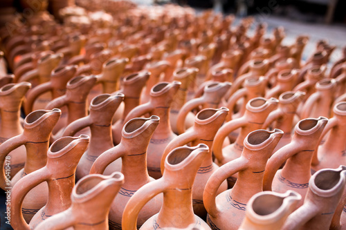 pottery, earthenware, clayware, crockery, stoneware. used for holding and pouring liquids.