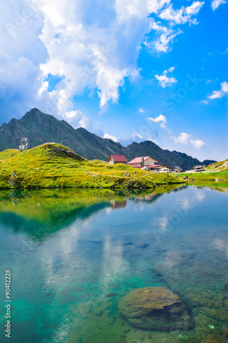 View with typical lodge on Balea Lake shore in Fagaras Mountains, Romania.