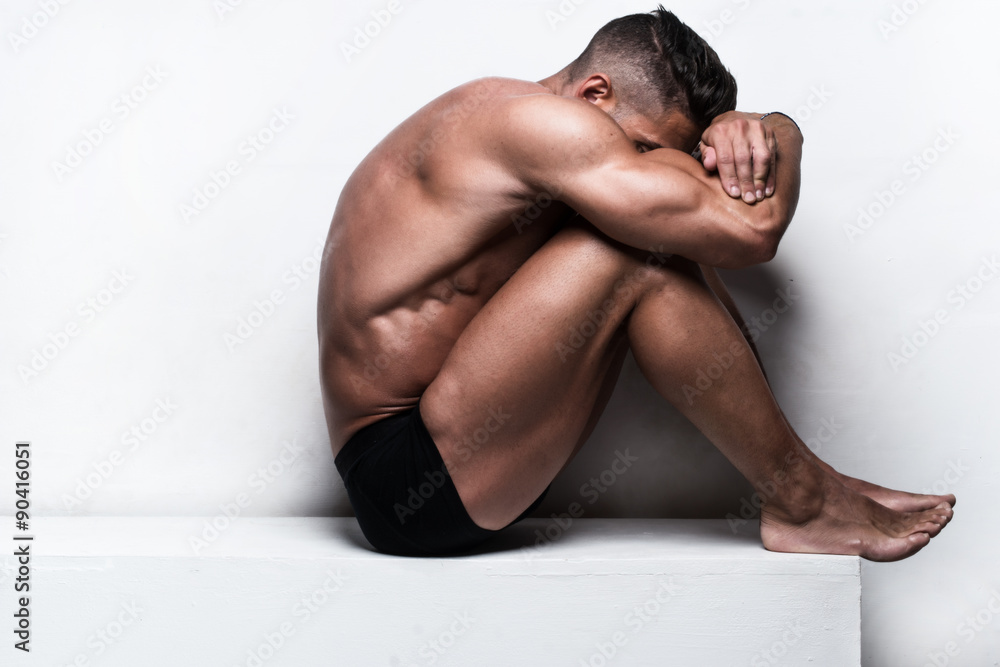 Muscular Man Sitting with Face Hidden Folded Arms Muscular Man Sitting with Face Hidden Folded Arms