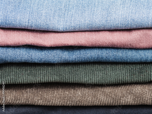 stack of various jeans and corduroy slacks
