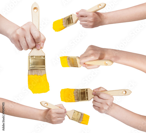 set of hands with flat paint brush with yellow tip photo