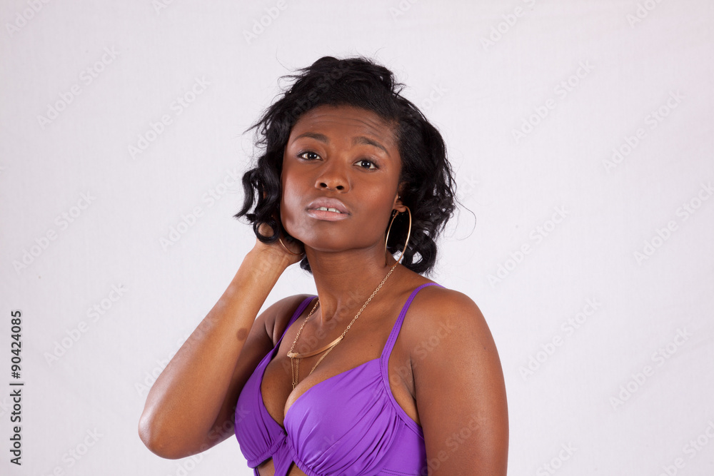 Pretty black woman in purple swim suit, looking thoughtful Pretty black woman in purple swim suit, looking thoughtful