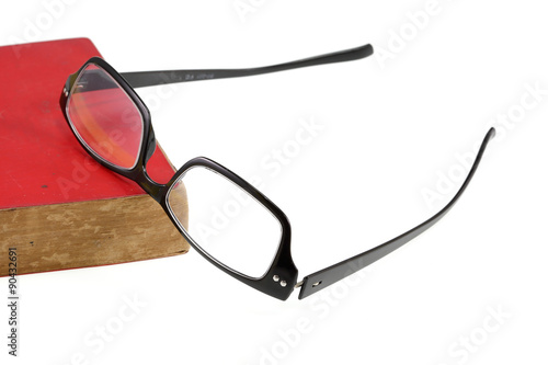 Red book and eyesglass on white background photo