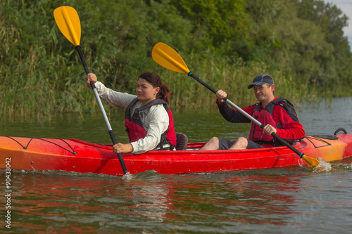 The couple goes kayaking on the river.