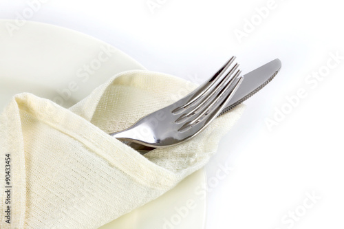 close up dinning silverware fork and knife with dish on white ba