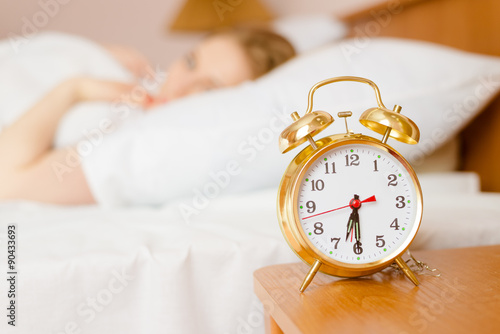 Retro alarm clock with sleeping lady on background