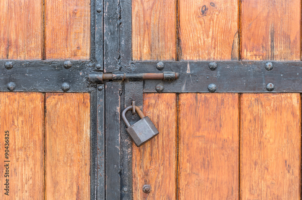 Wooden warehouse door secured with a latch and padlock