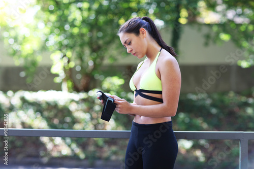 Sportliche Frau schaut auf ihr Handy