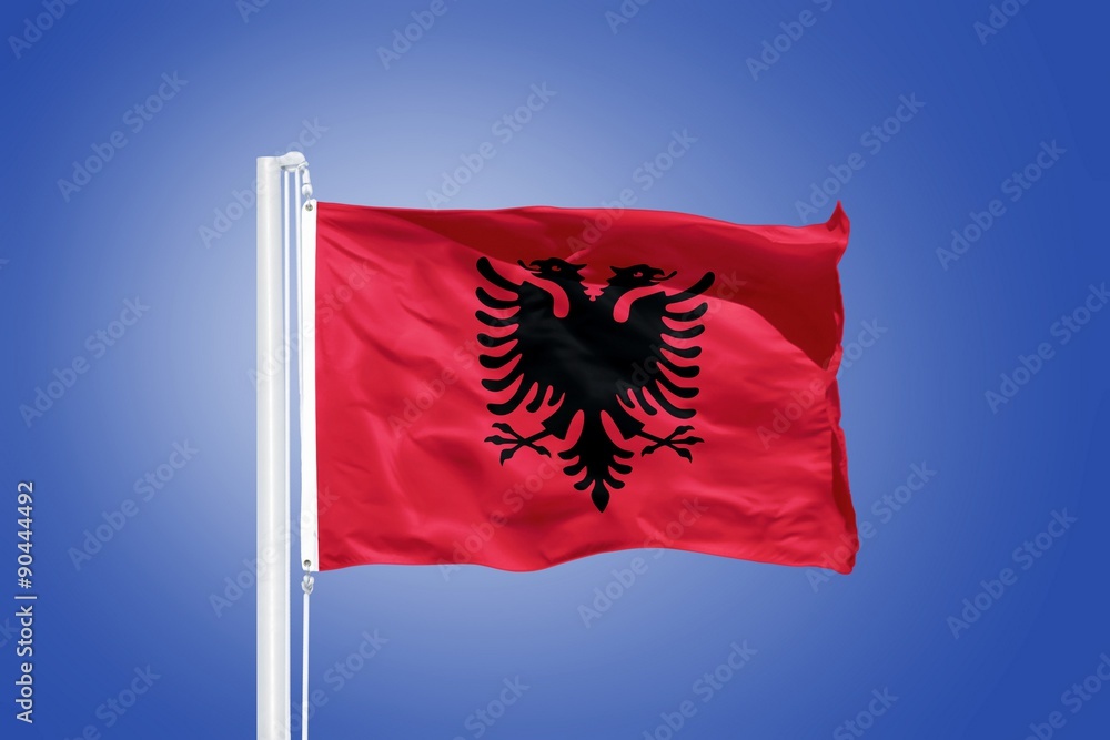 Flag of Albania flying against a blue sky Flag of Albania flying against a blue sky